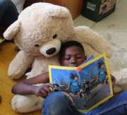 Child reading quietly with teddy bear